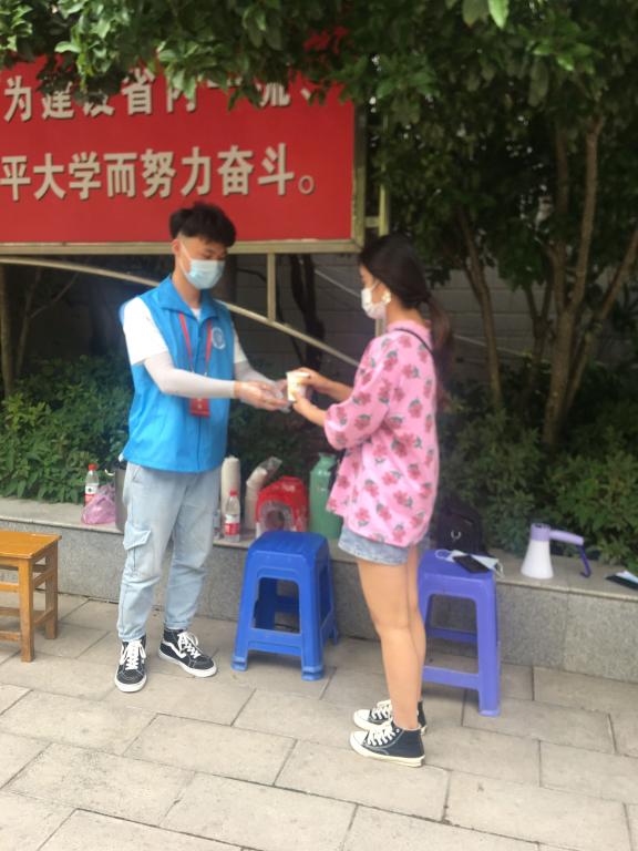 志愿者为返校学生提供解暑饮品