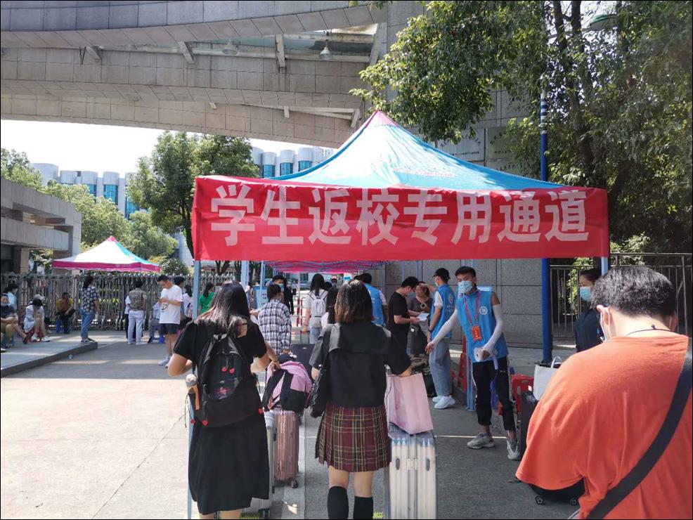 志愿者引导返校生保持安全距离,有序排队