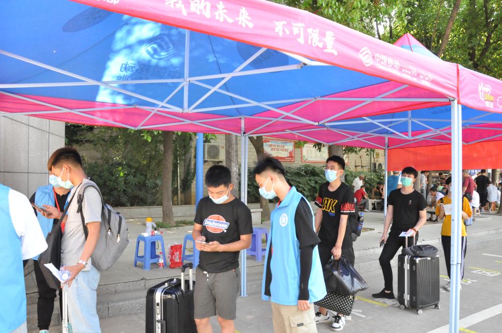 志愿者仔细核对学生安康码及身份证